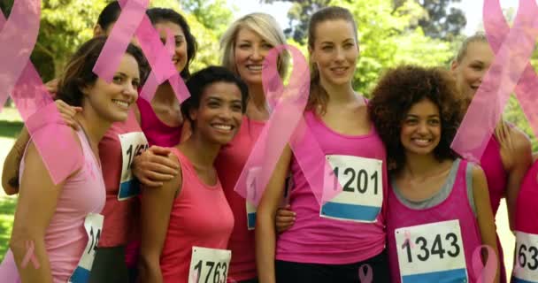 粉色丝带和锚标志的动画 漂浮在一群笑容满面的女赛跑选手之上 乳腺癌阳性女性健康意识运动概念数字制作视频 — 图库视频影像