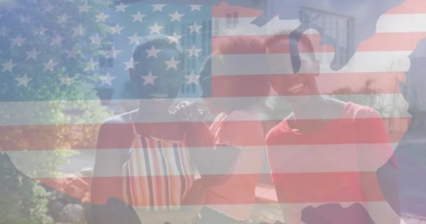 庭で幸せなアフリカ系アメリカ人の家族に対するウサの旗のアニメーション アメリカの愛国心と独立性の概念をデジタルで — ストック動画