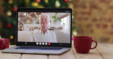 Dizüstü bilgisayardaki son sınıf öğrencisi mutlu Kafkas kadın, Noel süslemeleri ve ağacıyla. Noel, şenlik ve iletişim teknolojisi dijital kompozit video.