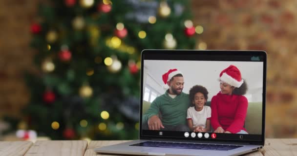 Szczęśliwa Rodzina Kapeluszach Mikołaja Telefonie Wideo Laptopa Dekoracjami Świątecznymi Choinką — Wideo stockowe