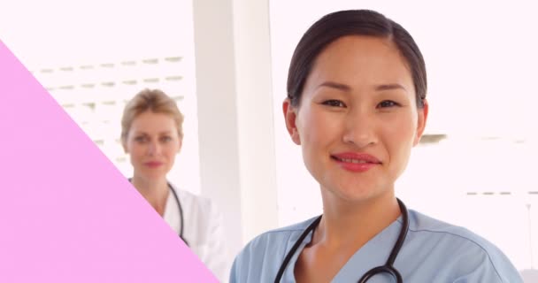 用粉红的乳腺癌彩带在两名微笑的女医生身上进行动画制作 乳腺癌认识运动概念数字化生成的视频 — 图库视频影像