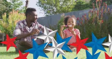 Afro-Amerikan baba ve kızının eğlenmesi üzerine kırmızı, mavi ve beyaz yıldızların animasyonu. Amerikan vatanseverliği ve bağımsızlık kavramı dijital olarak oluşturulmuş video.