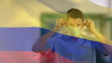Kolumbiya bayrağının, yüz maskesi takan beyaz bir doktorun üzerinde dalgalanması. küresel tıp, covid 19 pandemik konsept sırasında sağlık hizmetleri dijital olarak üretilen video.