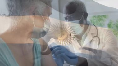 Arjantin bayrağının yüz maskesi takan ve son sınıf kadınını aşılayan doktorun üzerinde dalgalanması. küresel tıp, covid 19 pandemik konsept sırasında sağlık hizmetleri dijital olarak üretilen video.