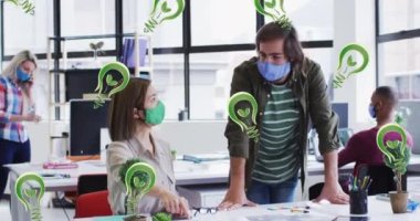 Yüz maskesi takan ve konuşan iş adamlarının üzerinde ampul simgelerinin canlandırılması. küresel ağlar, iş dünyası, veri işleme ve dijital arayüz kavramı dijital olarak oluşturulmuş video.