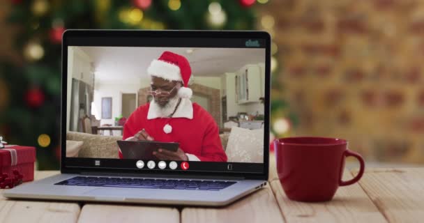 Senior Afrikanisch Amerikanischer Mann Weihnachtsmannkostüm Auf Videoanruf Laptop Mit Weihnachtsbaum — Stockvideo