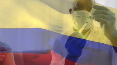 Kolumbiya bayrağının yüz maskesi takan ve aşı taşıyan doktorun üzerinde sallanışının canlandırması. küresel tıp, covid 19 pandemik konsept sırasında sağlık hizmetleri dijital olarak üretilen video.