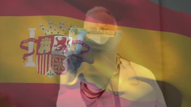 フェイスマスクを着用し ワクチンを保持する医師に手を振ってスペインの旗のアニメーション 世界中の医療や医療サービスをデジタル化し — ストック動画