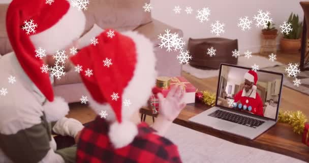 Animacja Śniegu Padającego Uśmiechniętego Ojca Syna Kapeluszach Mikołaja Laptopie Wideo — Wideo stockowe
