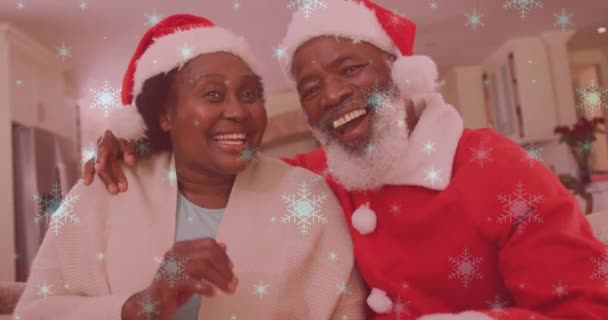 Animation Snow Falling Smiling Couple Wearing Santa Hats Waving Hands — Stock Video