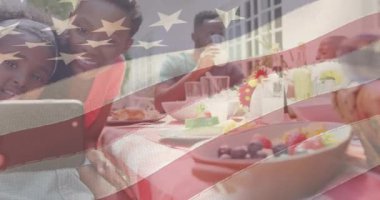 Aile yemeği yiyip selfie çekerken Amerikan bayrağının animasyonu. Vatanseverlik ve kutlama konsepti dijital olarak oluşturulmuş video.