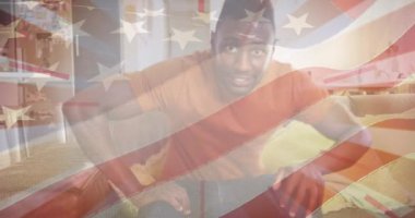 Amerika Birleşik Devletleri bayrağının animasyonu, koltukta oturan mutlu Afro-Amerikan erkek yerine. Amerikan vatanseverliği ve bağımsızlık kavramı dijital olarak oluşturulmuş video.