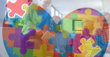 Renkli yapboz parçalarının animasyonu tablet kullanan yaşlı arkadaşlara göre kalbin üzerinde. otizm, öğrenme güçlüğü, destek ve farkındalık kavramı dijital olarak oluşturulmuş video.