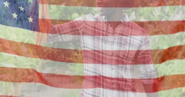 Animacja Flagi Stanów Zjednoczonych Ameryki Nad Szczęśliwym Afrykańskim Rolnikiem Trzymającym — Wideo stockowe