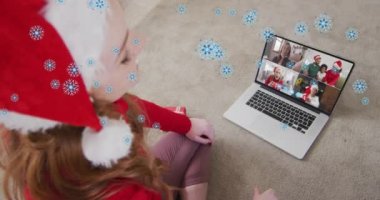 Noel Baba şapkalı mutlu beyaz kadın üzerindeki kar animasyonu ailesiyle birlikte dizüstü bilgisayarda görüntülendi. Noel, gelenek ve kutlama konsepti dijital olarak oluşturuldu.