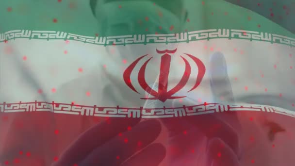 Animacja Flagi Iranu Machającego Nad Lekarzem Noszącym Maskę Twarzy Trzymającym — Wideo stockowe