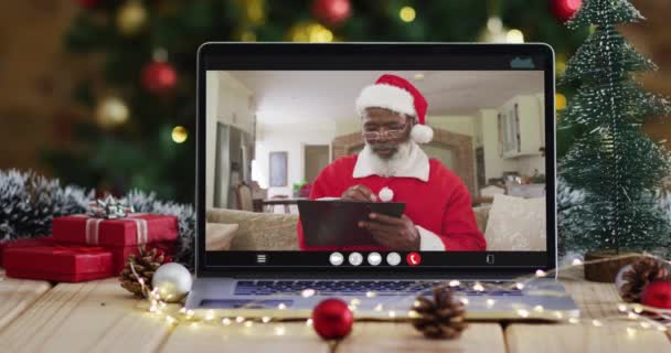 Senior Afrikanisch Amerikanischer Mann Weihnachtsmannkostüm Auf Videoanruf Laptop Mit Weihnachtsbaum — Stockvideo