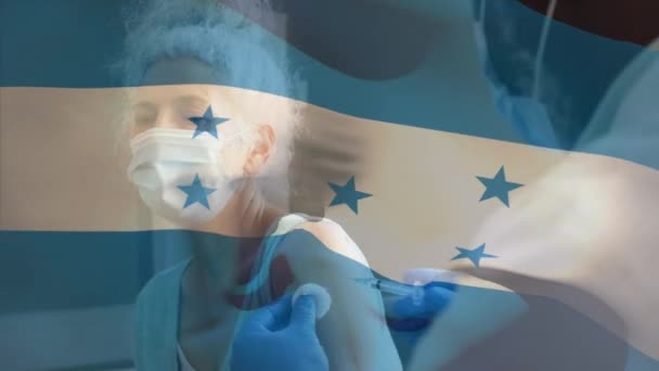 Animación Bandera Honduras Ondeando Sobre Médico Usando Mascarilla Facial Vacunando — Vídeo de stock