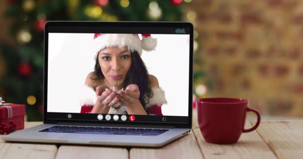穿着桑塔服装的快乐的高加索女人坐在笔记本电脑上 带着圣诞装饰品和圣诞树 节日和通信技术数码合成录像 — 图库视频影像