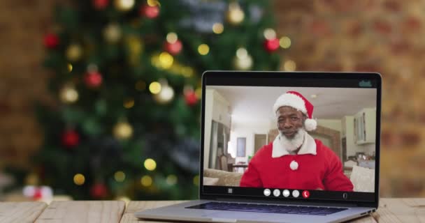 Senior Afrikanisch Amerikanischer Mann Weihnachtsmannkostüm Auf Videoanruf Laptop Mit Weihnachtsbaum — Stockvideo