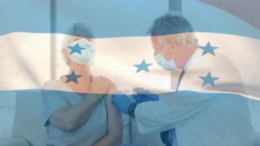 Yüz maskesi takan ve yaşlı kadınlara aşı yapan doktorların bayrak sallamalarının animasyonu. küresel tıp, covid 19 pandemik konsept sırasında sağlık hizmetleri dijital olarak üretilen video.