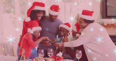 Akıllı telefon kullanarak gülümseyen aile ve Noel Baba şapkalarının üzerine yağan kar animasyonu. Noel, kış, gelenek ve kutlama konsepti dijital olarak oluşturulmuş video.