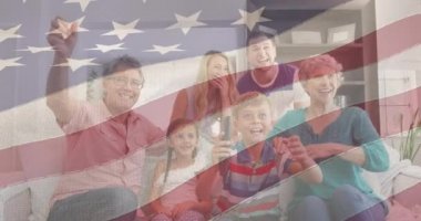 Amerikan bayrağının animasyonu, mutlu beyaz bir ailenin evde birlikte televizyon izlemesi üzerine. Vatanseverlik ve kutlama konsepti dijital olarak oluşturulmuş video.