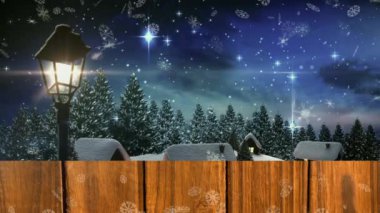 Kar taneleri, kış manzarasına ve gece gökyüzüne düşen kara karşı ahşap kalasların üzerinde. Noel şenliği ve kutlama konsepti