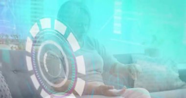 Sanal arayüzün maddeleşmesi, yaşlı kadının sağlık monitörünü kontrol etmek için bileğini kaldırmasını tetikliyor. Gelecekçi, sağlıklı, teknoloji, yaşlılar, yerli, yenilik, arayüz