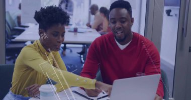 Kırmızı kazak sarı bluz meslektaşları ofis masasında dizüstü bilgisayarı inceliyor, üzerinde kağıt kalem suyu var. İşbirliği, takım çalışması, modern, profesyonel, çalışma alanı, üretkenlik, gündelik