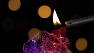 Metal alevler fitillere dokunur, alevler alevlenir ve sıcak parıltı için renkli dumanlar yükselir. Mumlar, alevler, aydınlanma, ortam, ışıltı, sanatçılık, kontrast