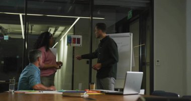 Ekip üyeleri toplantı odasındaki cam bölmelerdeki renk izlerini not defterleriyle değerlendiriyorlar. İşbirliği, takım çalışması, tartışma, kurumsal, profesyonel, modern, iç mekan