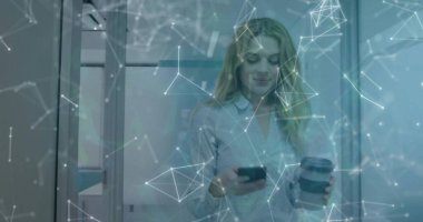 Akıllı telefon ve kahve fincanı tutan, ofiste cam duvarları olan, ağ kaplamalı bir kadın. Teknoloji, bağlantı, profesyonel, modern, dijital, çalışma alanı, yenilik