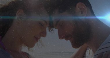 Güneşli sahilde alnı birbirine bastıran çift mercek alevi ve okyanus suyuyla. Romantizm, dinginlik, manzara, yaşam tarzı, sükunet, birlik, doğal