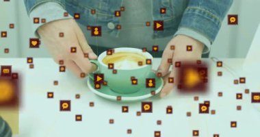 Adam fincan tabağı kaşığı düzenliyor sonra da elini kesiyor sosyal medya simgelerinin latte 'nin etrafında dönmesine neden oluyor. Minimalist, modern, dijital, sosyal, teknoloji, yaşam tarzı, gelişigüzel