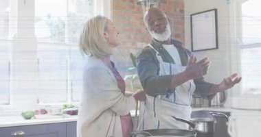 Kadın ev yemeğinden önce erkeğin üzerine önlük takıyor, erkek mutfağı doldururken kıpırdıyor. Aile içi, arkadaşlık, aşçılık, konfor, etkileşim, yaşam tarzı, sıcaklık.