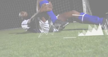 Erkek futbolcu dizini kavrayıp spor verilerini aktifleştiriyor stresi takip ediyor ve kolunu kaldırıyor. Sporcu, performans, sakatlık, iyileşme, analiz, fitness, rekabet