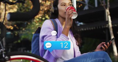 Kadın bankta kahvesini yudumluyor akıllı telefonu kontrol ediyor sosyal medya sohbet baloncuğu numaraları 95 'e yükseliyor. Günlük, açık hava, yaşam tarzı, kentsel, canlı, rahat, teknoloji