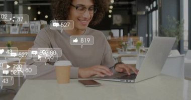 Telefonunu dinleyen ve dizüstü bilgisayarda yazan adam sosyal medya bağlantısını gösteren yüzen uyarıları başlatıyor. Teknoloji, iletişim, dijital, çalışma alanı, bağlantı, yenilik, modern