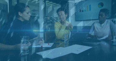 İşbirliği yapan iş kadınları hardal kazak giyip toplantı odasındaki çizelgeleri tabletle gözden geçiriyorlar. İş, takım çalışması, strateji, veri, profesyonel, kurumsal, analiz