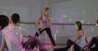 Stüdyoda geniş bacaklı pozlarla katılımcılara rehberlik eden bir eğitmen. Finansal tablolarla birlikte. Sağlık, fitness, meditasyon, dijital, modern, grup, motivasyon