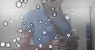 Kot bluzlu, gülümseyen İspanyol kadın modern ofiste elinde akıllı telefon, sohbet ve avatar simgeleriyle. Teknoloji, iletişim, profesyonel, ağ oluşturma, dijital, işbirliği, modernite