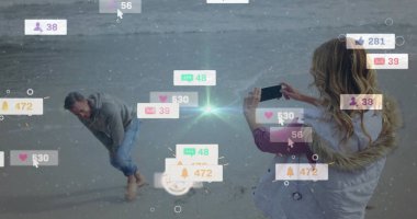 Plajda tebligat simgeleriyle kukuletalı çerçeveli adam kullanan akıllı telefon kadın, kopyalama alanı. Kıyı, eğlence, samimiyet, yaşam tarzı, sosyal, modern, bağlantı