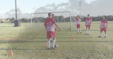 Top süren oyuncu külahlarda top topluyor ve konilerden geçerek spor taliminde kaleye doğru ilerliyor. Sporcular, takım çalışması, eğitim, çeviklik, disiplin, açık hava, rekabetçi