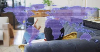 Pazarlamacı, veri analizi için kanepenin etkin mor dünya haritasından karton kapaklı kitabını alıyor. Teknoloji, bağlantı, modern, yaşam tarzı, dijital, rahatlama, çevre