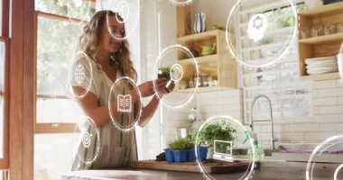 Teknoloji simgeleri büyümeyi gösterirken bir kadın toprak tepsisinden bitki tohumu topluyor ve saksılıyor. Bahçıvanlık, sürdürülebilirlik, yenilik, ev, şehir, beslenme, dekor