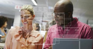 Meslektaşlar ofisteki cihazları göstererek ve tıkırdatarak iş analizleri için grafikler gösteriyorlar. İşbirliği, yenilik, analitik, dijital, teknoloji, takım çalışması, ofis