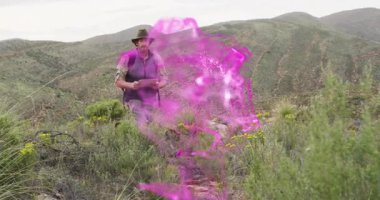 Yetişkin erkek otostopçu mor sislerin ardından seyahat haritası kullanarak bacakların etrafındaki izleri takip ediyor. Macera, keşif, vahşi doğa, keşif, yalnızlık, manzara, doğa.