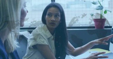 İş toplantısına başlayan bir kadın meslektaşına döner, kağıtların üzerinde işaret eder ve konuyu vurgular. Profesyonel, işbirliği, kurumsal, iletişim, modern, çalışma alanı, tartışma