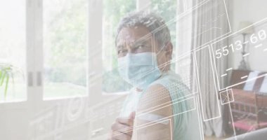 Üst düzey bir adam aşıdan sonra kolları bandajlı bir şekilde odada, etrafında sağlık verileri panellerle dolaşıyor. Yaşlılar, konfor, teknoloji, sağlık, rahatlama, dijital, sağlık